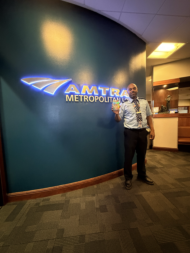 Amtrak station manger holding a copy of Flip[ 7!